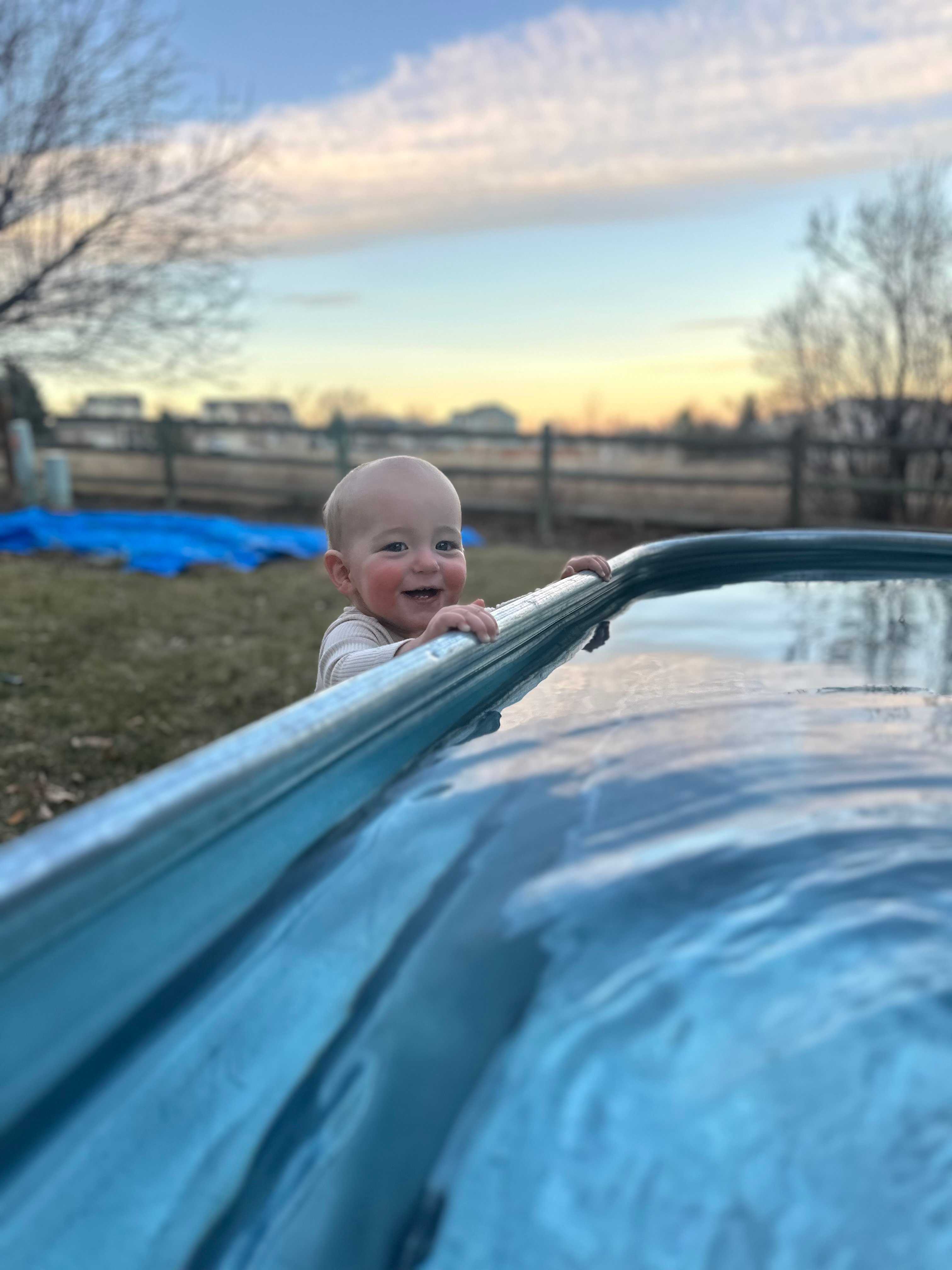 Palmer cold plunging while his young son watches and smiles